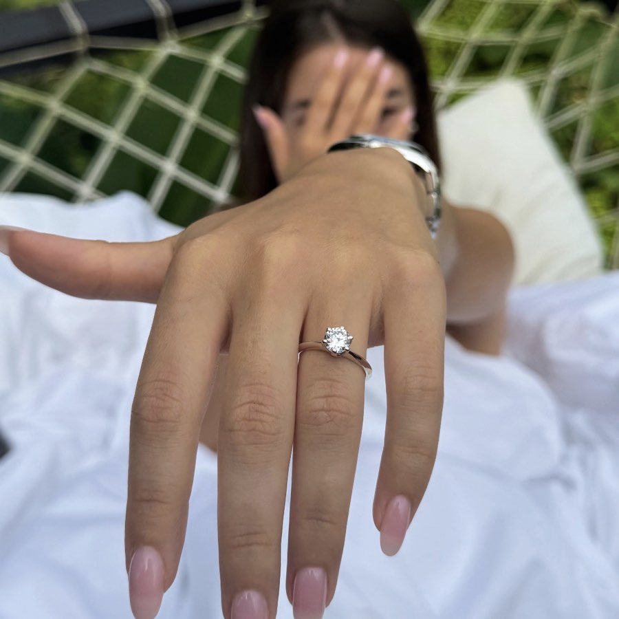 solitario anello 6 griffe indossato da una ragazza emozionata dopo aver ricevuto l'anello per una proposta di matrimonio.